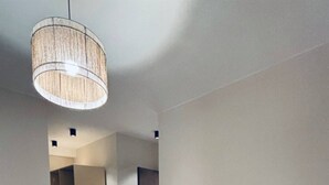 A modern hotel room with a large bed, a bedside table, and a hanging light fixture. - Apartment 2 in Zed Towers (El Sheikh Zayed City)