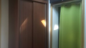 A room with a wooden wardrobe and a green curtain. - Holiday Home Under the Pines with Shared Pool, Private Terrace, and Wi-Fi (Moliets-Et-Maa)