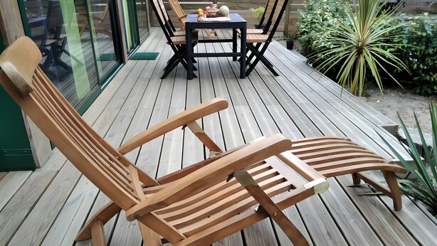 A wooden deck with two lounge chairs and a table with chairs. - Holiday Home Under the Pines with Shared Pool, Private Terrace, and Wi-Fi (Moliets-Et-Maa)