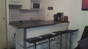 A compact kitchen with a microwave, coffee maker, and a washing machine. - Holiday Home Under the Pines with Shared Pool, Private Terrace, and Wi-Fi (Moliets-Et-Maa)