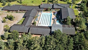 An aerial view of a residential area with multiple houses, a swimming pool, and a large green field. - 4 Person Holiday Park Home in Gilleleje (Gilleleje)
