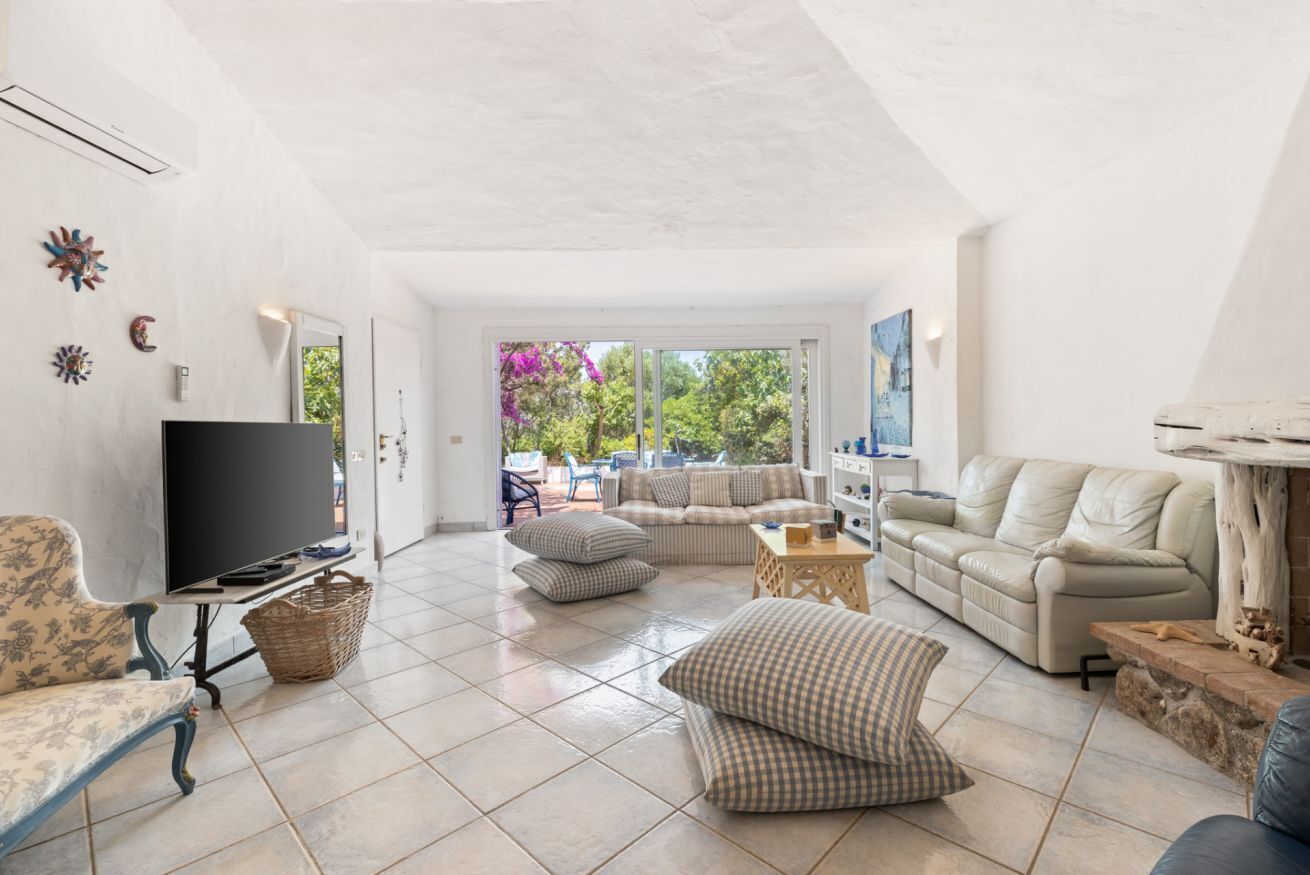 A spacious living area with a flat-screen TV, sofas, and a coffee table.