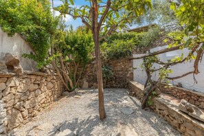 A courtyard with a tree, stone walls, and a gravel ground. - Villa Panta Rei - Liscia di Vacca (Liscia di Vacca)