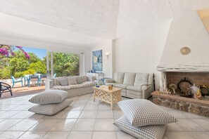 Un amplio salón con un conjunto de sofás, una mesa de centro y una chimenea.