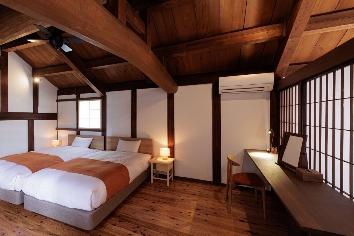 Une chambre à coucher avec un grand lit, des tables de chevet, un bureau et une fenêtre.