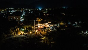 A nighttime aerial view of a town with illuminated buildings and streets. - Ashreya Suites Tiruvanamalai (Tiruvannamalai)