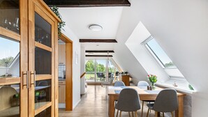 Eine moderne Küche mit Holzschränken und einem Essbereich mit Tisch und Stühlen.