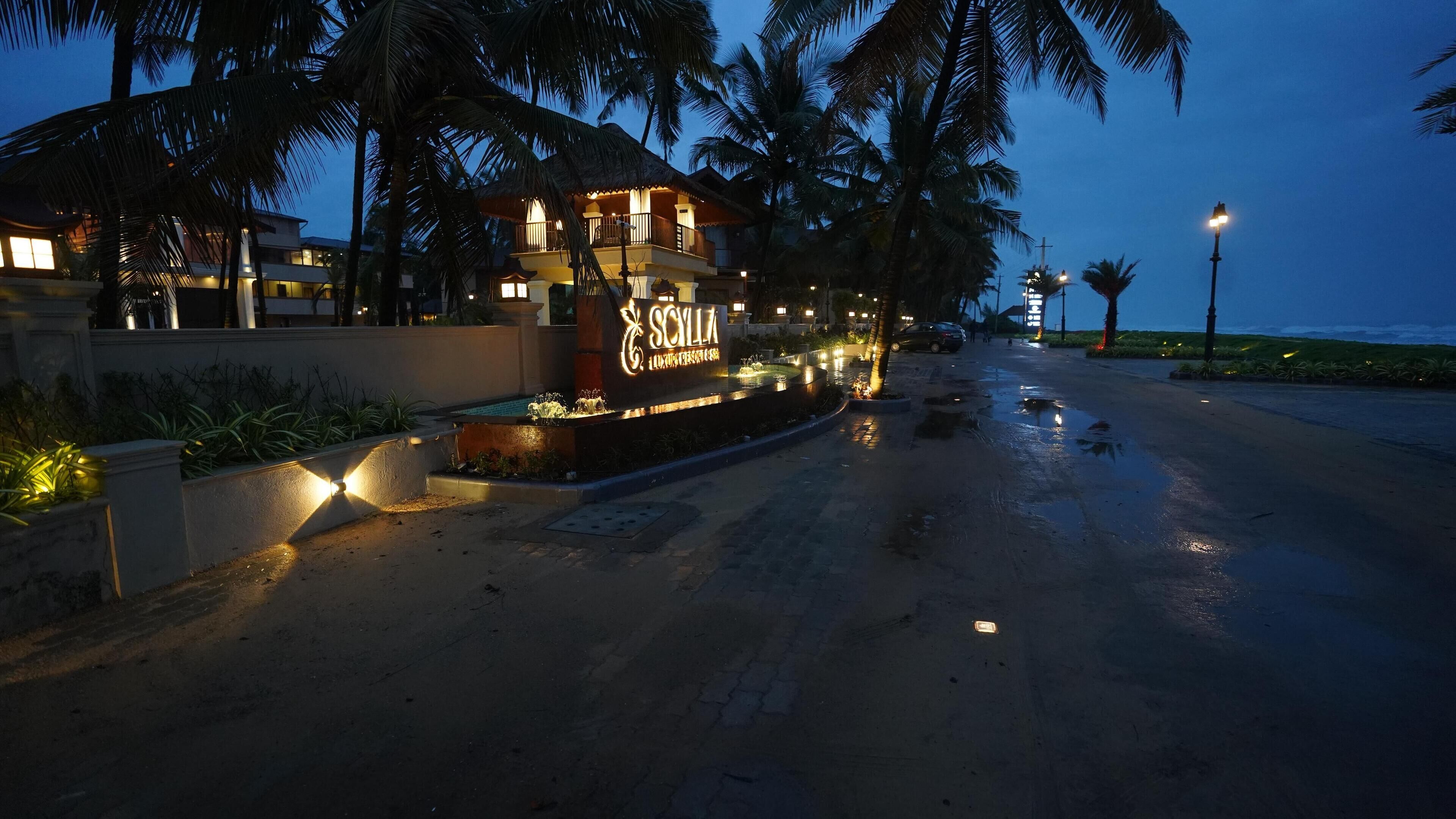 A resort with a sign reading "Scilla Luxury Resort & Spa" at dusk.