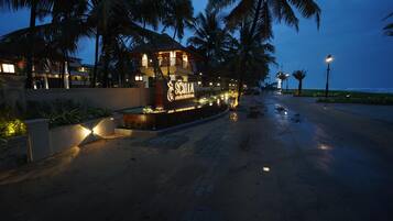 A resort with a sign reading "Scilla Luxury Resort & Spa" at dusk.