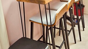 Un comedor con mesa de madera y cuatro sillas, tragaluz y vista al cielo.
