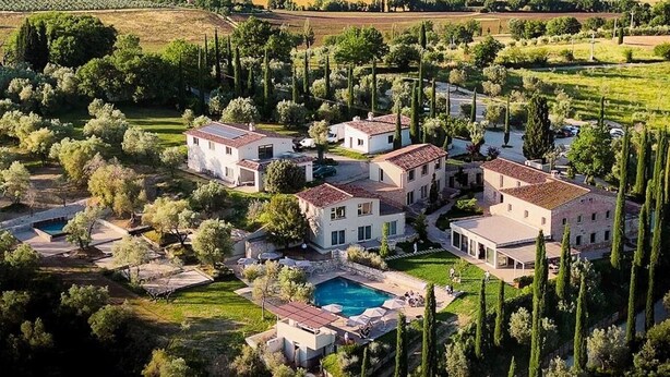 A residential area with multiple houses, a swimming pool, and a mountainous backdrop. - Borgo del Lago (San Gemini)