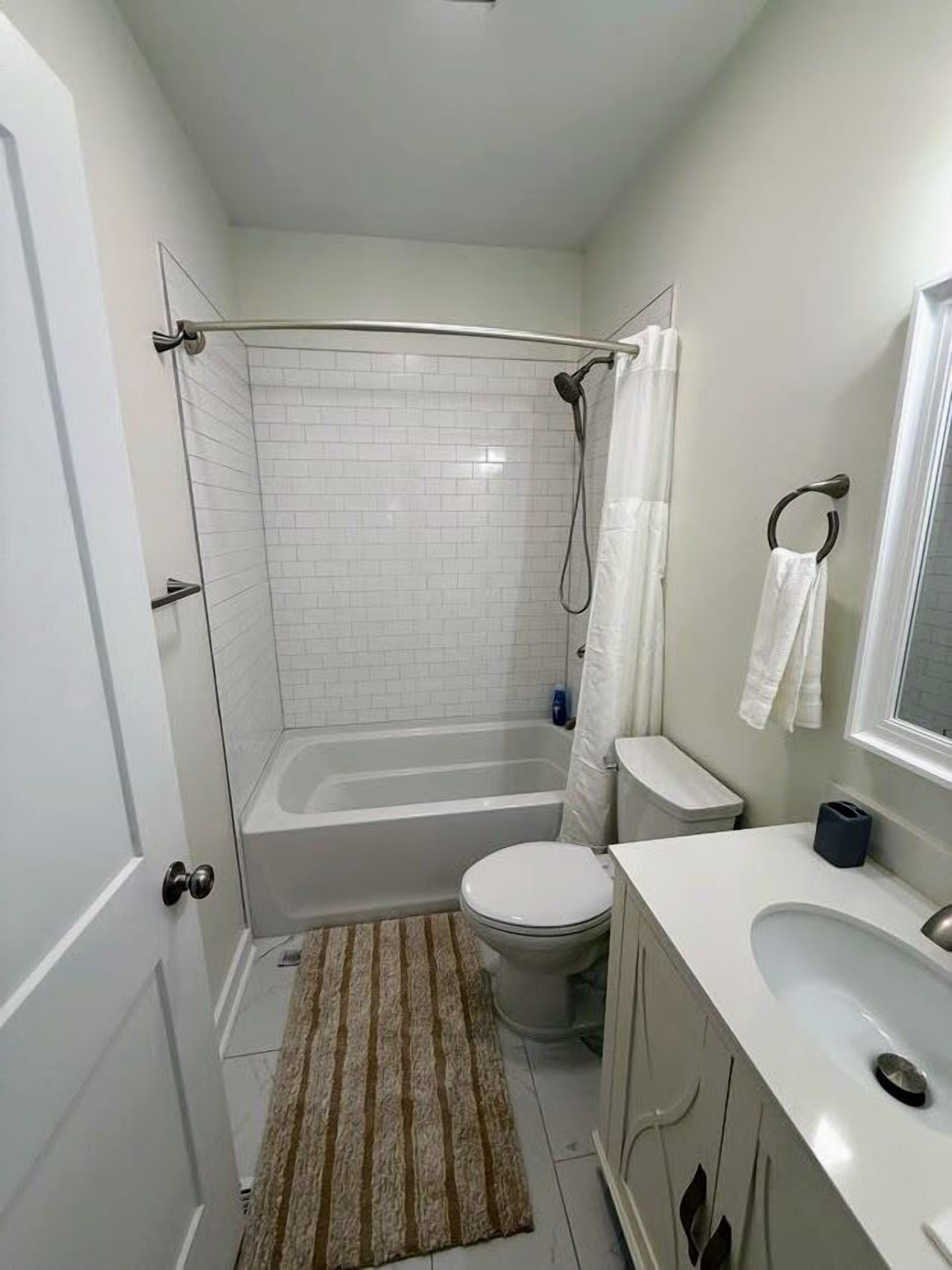 A bathroom with a bathtub, toilet, and sink.