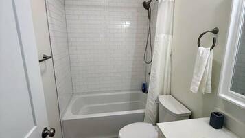 A bathroom with a bathtub, toilet, and sink.