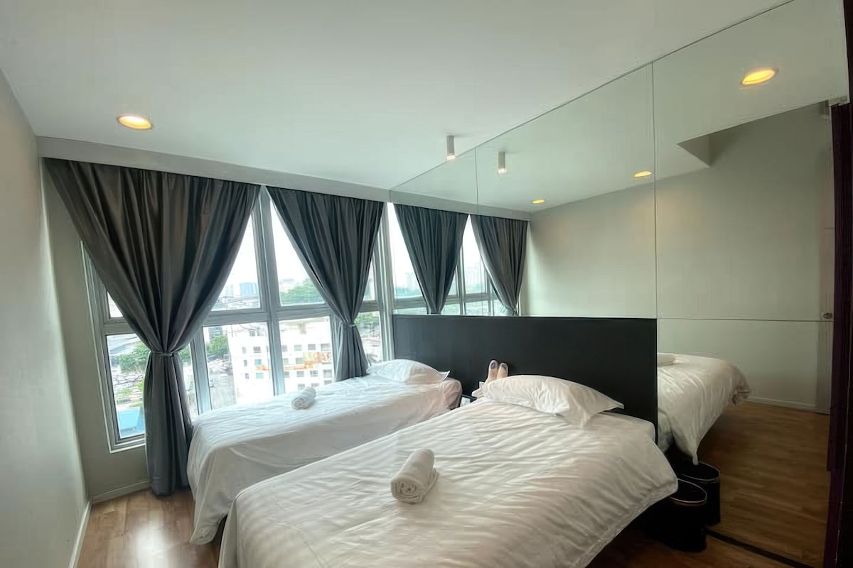 A hotel room with two beds, large windows with curtains, a wooden floor, and a modern design.
