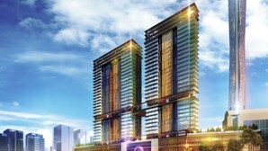 Un immeuble moderne de grande hauteur, doté d’une façade élégante en verre et d’un élément de design vertical particulièrement marqué.