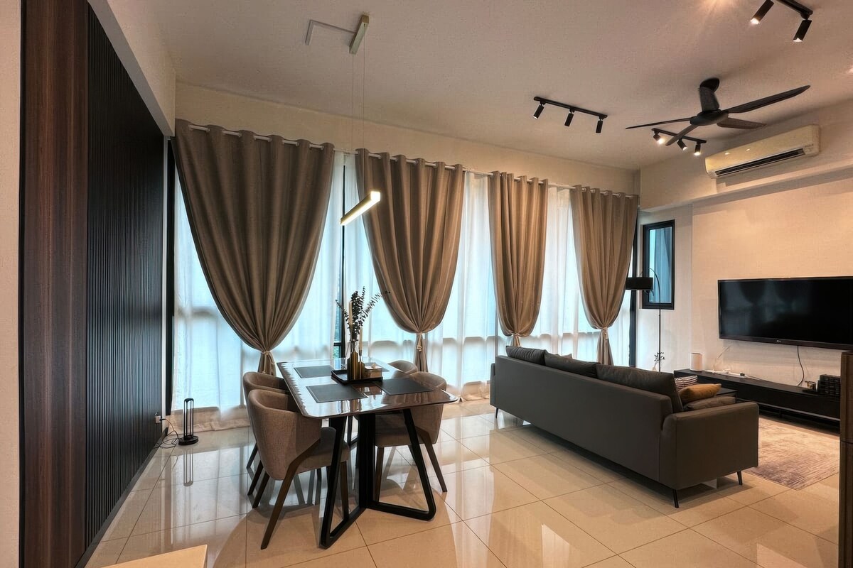 A modern living room with a sofa, TV, and dining area with a table and chairs.
