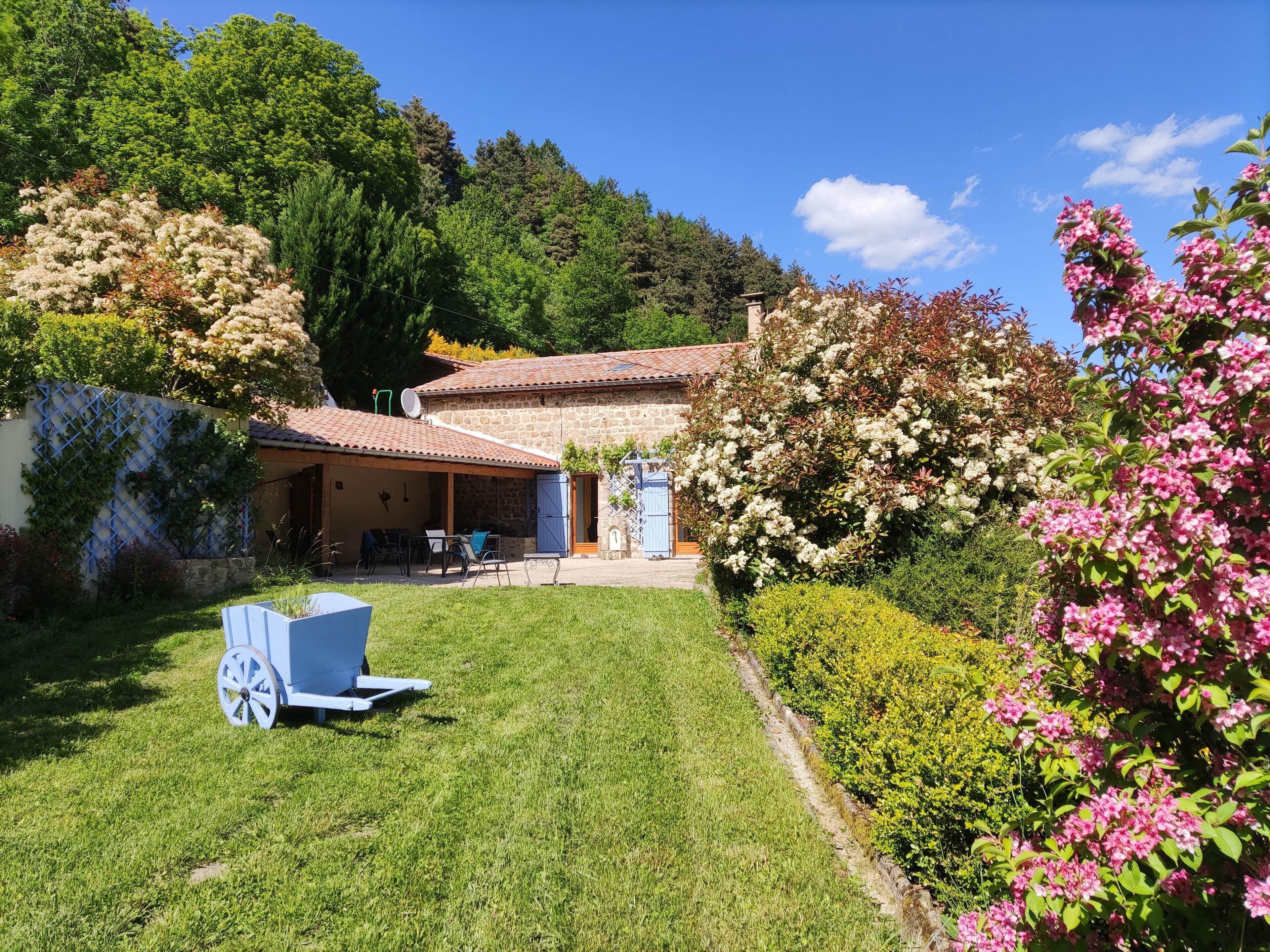 Vue devant la maison avec une partie du jardin et terrasse plein sud