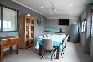 A modern kitchen with grey cabinets, a built-in oven, and a large refrigerator. - Sandy Feet Retreat Su (Peterborough)