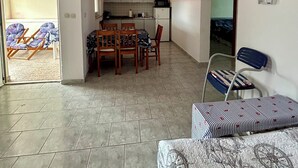 A compact living space with a dining area, kitchen, and a small seating area with a patterned sofa. - Charming 2-bedroom terrace apartment in amazing Vir, Walk to North&South Beaches (Vir)