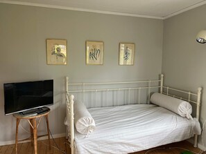 A bedroom with a bed, a television on a stand, and three framed pictures on the wall. - 5 Person Holiday Home in Varmdo (Värmdö)