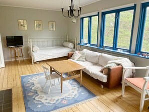 Une pièce comprenant un lit, un canapé, une table et un téléviseur.