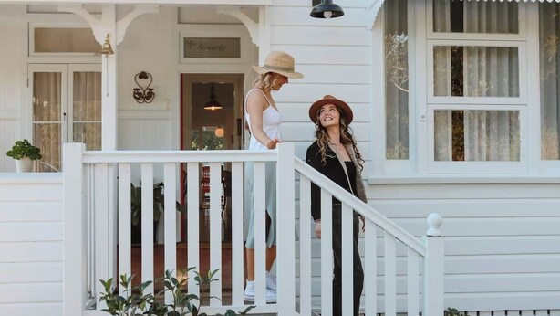 A white building with a porch and a staircase.