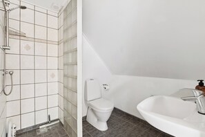 A bathroom with a shower, toilet, and sink.