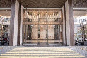 Une entrée moderne avec une façade en verre et le nom « CORSETT » affiché en évidence.
