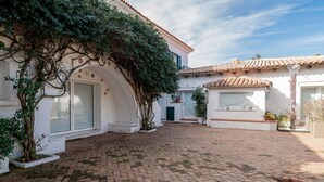 A courtyard with a brick floor, white walls, and terracotta roof tiles. - Locanda Tartarughino - Suite Luna (Porto Rotondo)