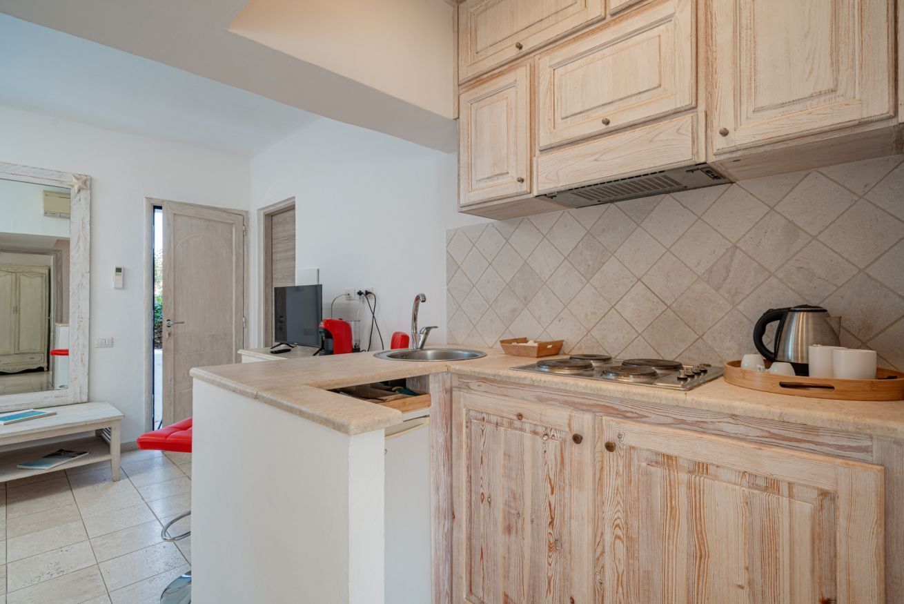 Una cocina con armarios de madera, una encimera y salpicadero de azulejos.