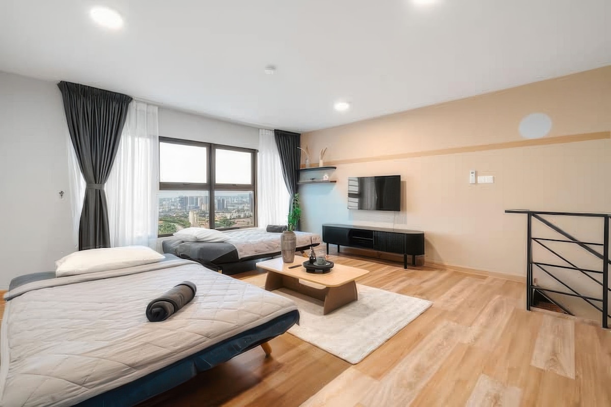 Une chambre d’hôtel moderne avec deux lits, une télévision, une petite table et une vue sur la ville.