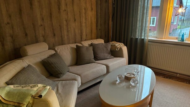 A living room with a sofa, a coffee table, and a window with curtains. - 4 Person Holiday Park Home in Rolfstorp (Rolfstorp)