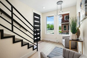 A modern interior with a staircase, a living area with a sofa, a coffee table, and a potted plant. - New Luxe Downtown- Modern San Antonio Retreat (San Antonio)