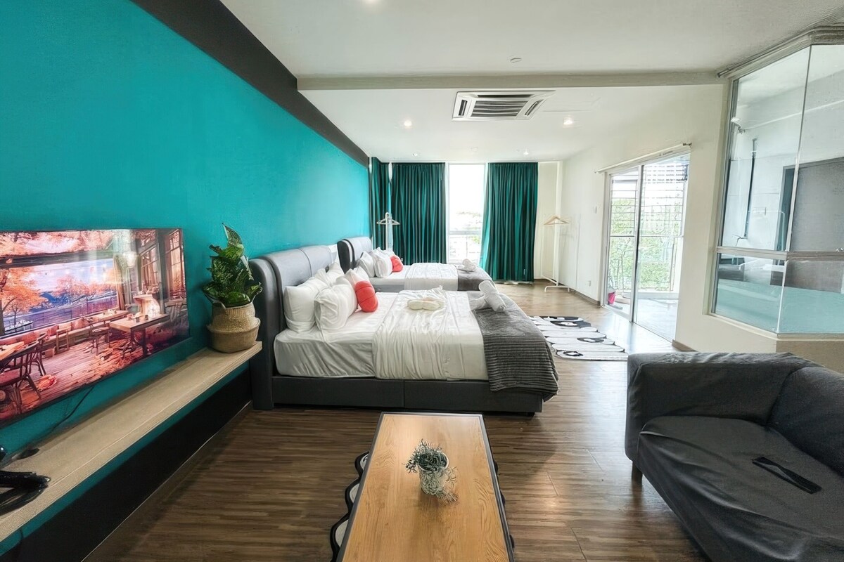 Una habitación de hotel moderna con una cama grande, un sofá, una mesa de centro y un televisor en la pared.
