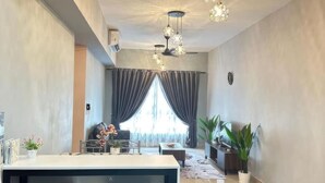 A spacious living area with a modern kitchen, a dining area with bar stools, and a large window with curtains.