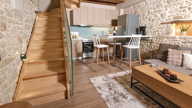 Een moderne keuken met houten kasten, een bar en een stenen muur.