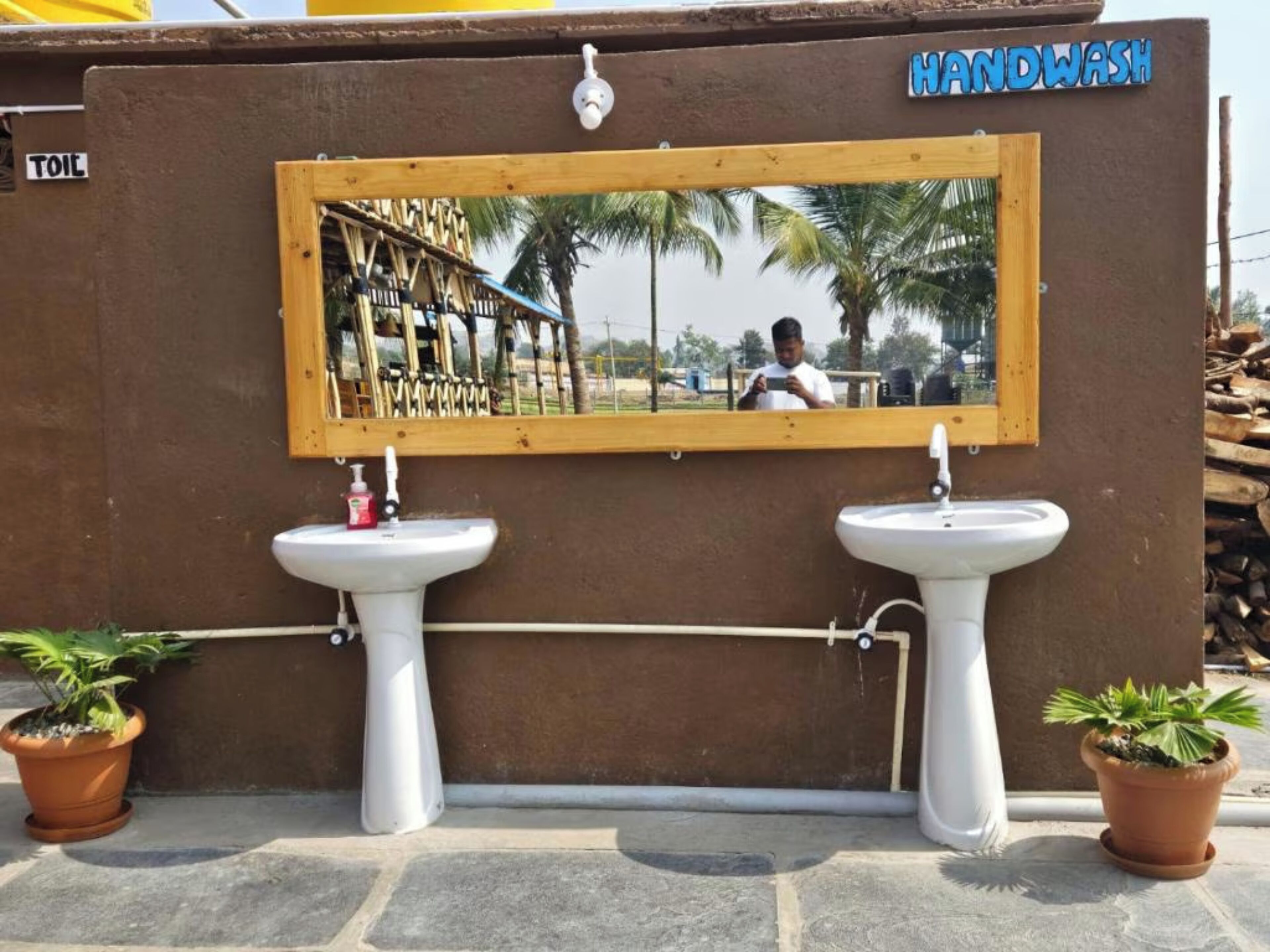 A handwashing station with two sinks and a mirror.