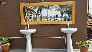A handwashing station with two sinks and a mirror.
