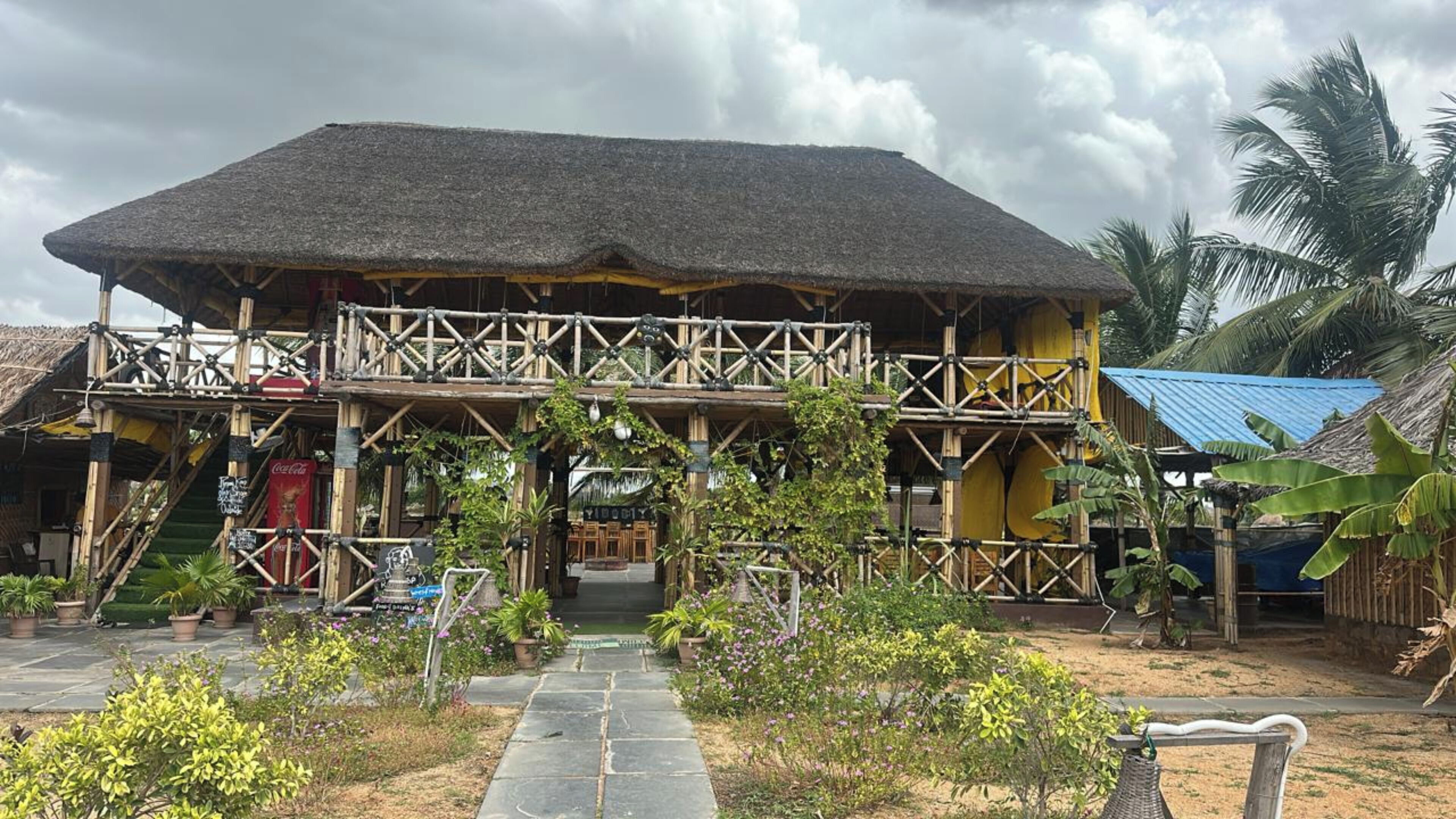 A two-story building with a thatched roof and a wooden balcony.