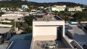 Terraza en la azotea con un diseño arquitectónico moderno, que incluye un techo plano y una pequeña zona de estar.