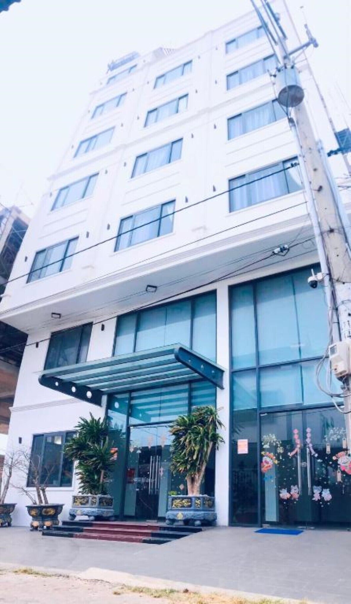 Um hotel moderno com entrada de vidro e galeria coberta.