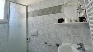 A modern bathroom with a toilet, bidet, sink, and a mirror. - HOTEL DINKLI (Rimini)