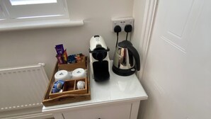 A small white bedside table with a drawer, a kettle, and a power outlet. - Charming Friendly bed & breakfast in serene north Cardiff with WiFi (Thornhill)