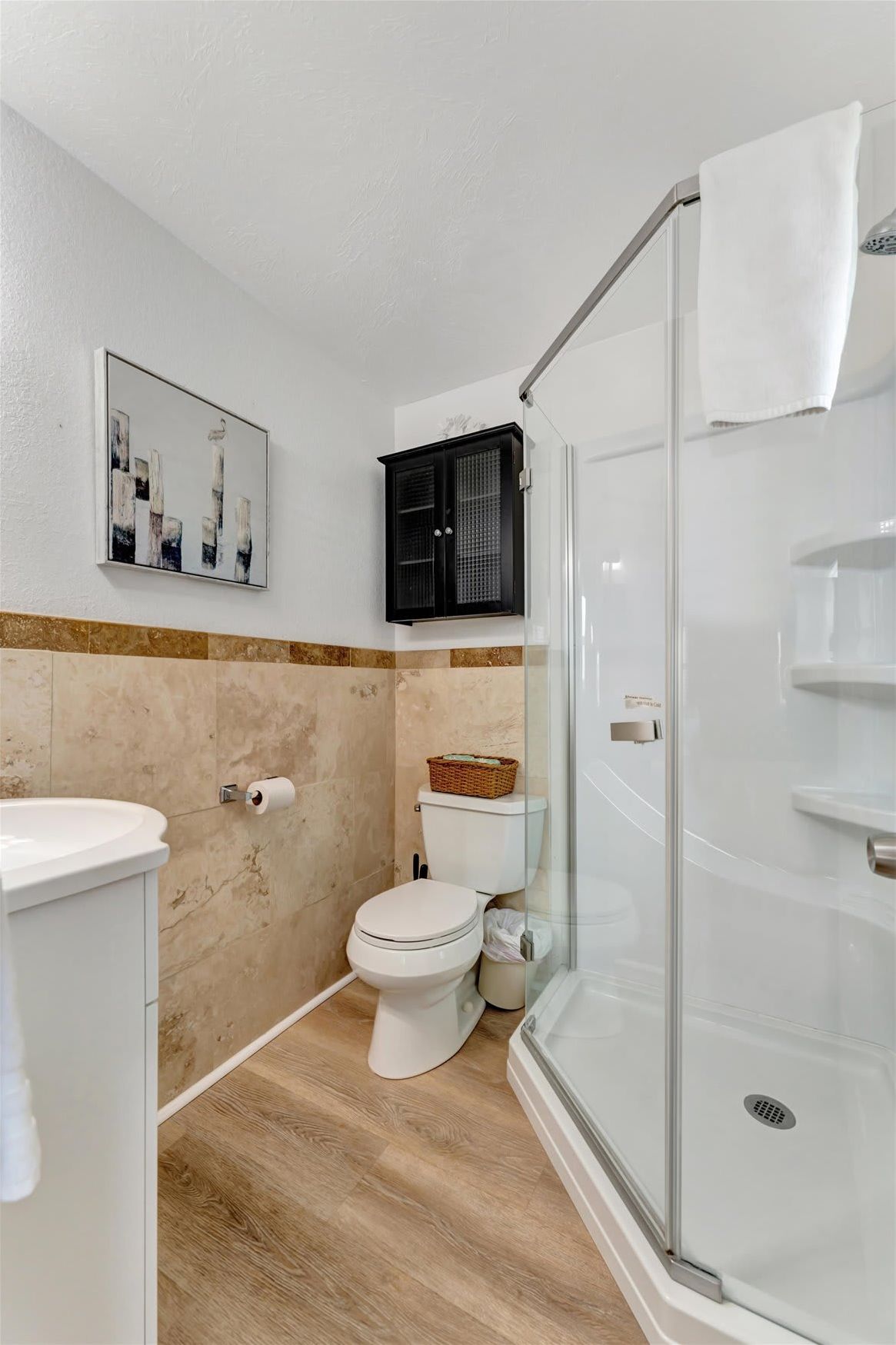 Your private bathroom features a walk-in shower, warm wood-look flooring, and stylish neutral tones that create a comfortable, refreshing space.