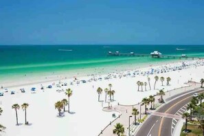 This stunning coastal area features pristine white sand beaches and emerald waters, with a nearby pier extending into the Gulf. Palm trees line the beachfront promenade, part of the vibrant surrounding neighborhood. - Right on Clearwater Beach! Corner Suite Waterview (Clearwater)