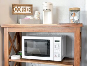 A microwave oven on a wooden shelf with a coffee sign above it. - Right on Clearwater Beach! Corner Suite Waterview (Clearwater)