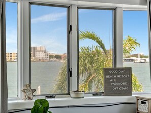 A window with a view of a body of water and buildings, a starfish decoration, a small plant, and a sign with a password. - Boho Studio B-4: Intracoastal Views, Shared Heated Pool & Dock (Clearwater)