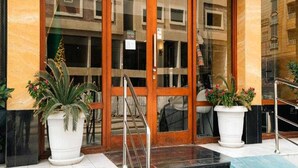 A hotel entrance with a wooden door, glass panels, and a staircase leading up. - Sunday Gateway Jeddah Formerly Beach Garden Hotel (Jeddah)