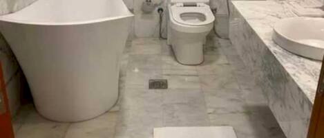 A bathroom with a bathtub, toilet, and sink.