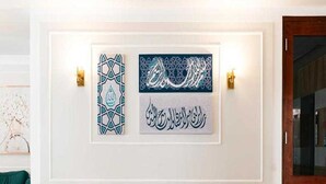 A modern lobby with a marble floor, two white chairs, a small round table, and three framed calligraphy pieces on the wall. - Sunday Gateway Jeddah Formerly Beach Garden Hotel (Jeddah)